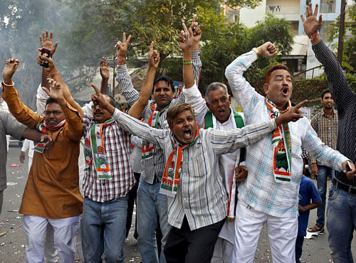 Supporters of Congress party celebrate after learning of initial results outside the party office in Ahmedabad. Reuters photo