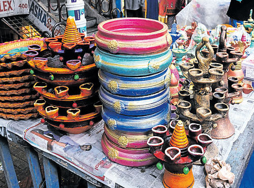 MANY HUES:Avariety of diyas (lamps) are on display at a stall in Malleswaram on Monday. DH PHOTO