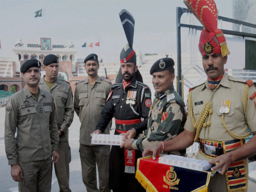 BSF officials offer sweets to Pakistani Rangers officials on the occasion of Diwali festival at Indo-Pak Attari-Wagha border on Wednesday. PTI Photo.
