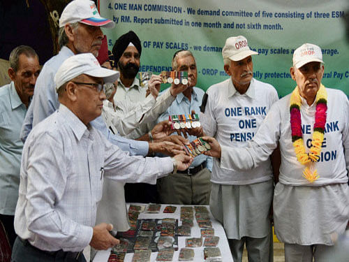 Ex-servicemen returing their medals during their agitation for One Rank One Pension (OROP) scheme benefits and privileges at Jantar Mantar in New Delhi on Tuesday. PTI photo