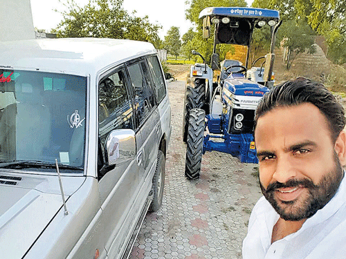 A Punjabi poses in front of his tractor.
