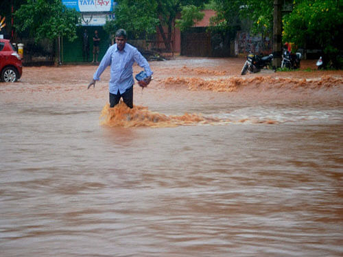 A man wades through rainwater after heavy rains at Vadalore in Cuddalore district. PTI photo