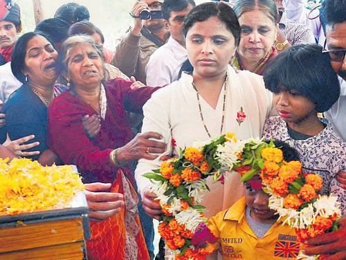 Grief-stricken: Wife, mother and other family members pay floral tributes at the mortal remains of Colonel Santosh Y Mahadik during his cremation ceremony in Satara, Maharashtra on Thursday. PTI