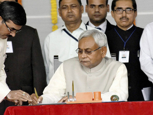 Nitish Kumar signing the register after taking oath as the Chief Minister of Bihar at Gandhi Maidan in Patna. PTI Photo