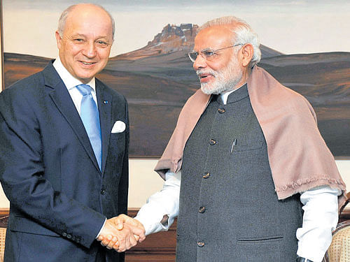 Prime Minister Narendra Modi shake hands with French Foreign Minister Laurent Fabius in a meeting in New Delhi on Friday. PTI Photo