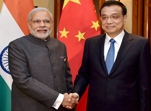 Prime Minister Narendra Modi shakes hands with Chinese Premier Li Keqiang at a meeting in Kuala Lumpur, Malaysia on Saturday. PTI Photo