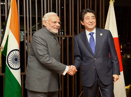 Prime Minister Narendra Modi shakes hands with his Japanese counterpart Shinzo Abe at a meeting in Kuala Lumpur, Malaysia on Saturday. PTI Photo