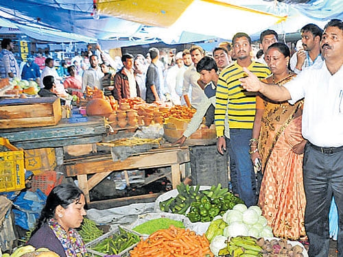 BBMP staff ask footpath vendors to clear the footpath inside the Jayanagar Commercial Complex on Saturday. DH PHOTO
