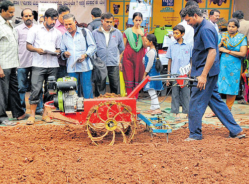 NEW-AGE TOOL: People look on as a farm equipment is being demonstrated at GKVK in Bengaluru on Sunday, the last day of Krishi Mela. DH PHOTO