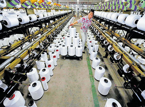 SPOOLING TROUBLE: An employee works inside a textile factory in Linhai, Zhejiang province. After decades of debt-driven investment, economists are wondering whether China can shift to a model in which consumer demand becomes the main engine of economic growth. REUTERS