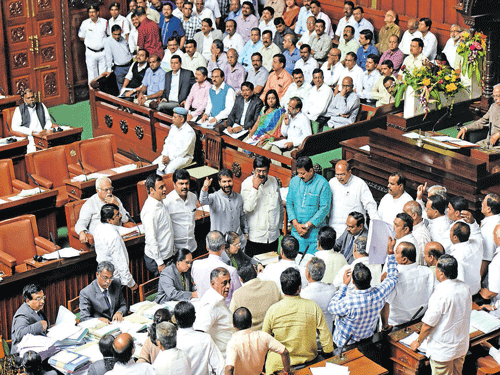 BJP members stage a dharana in the well of House during the Legislative Assembly session at the Vidhana Soudha on Thursday, demanding Social Welfare Minister H Anjaneya's resignation. DH&#8200;PHOTO