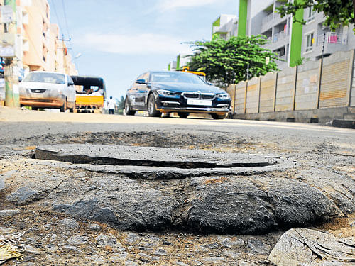 A crater-like pothole poses a grave threat to motorists in one of the roads in Whitefield area. Dh Photos/ B H ShivaKumar