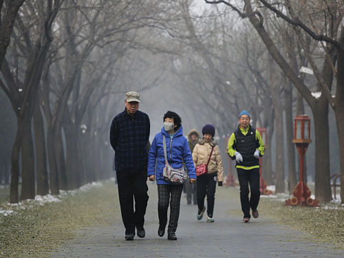 People walk in a park on a heavily polluted morning in Beijing, China, November 29, 2015. Beijing plans to ramp up its already tough car emission standards by 2017 in a bid by one of the world's most polluted cities to improve its often hazardous air quality. REUTERS Photo