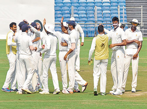 IN HIGH SPIRITS: Karnataka players celebrate the fall of a Maharashtra batsman in Pune on Tuesday. DH PHOTO