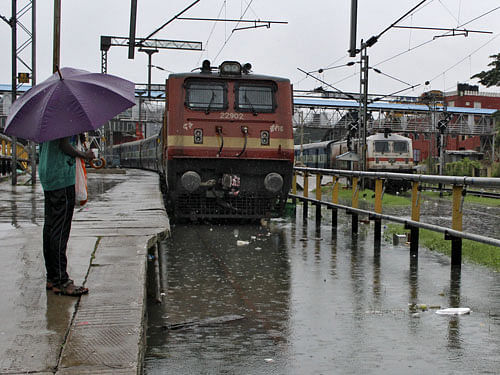 A man stands next to a flooded railway track as it rains in Chennai. reuters photo