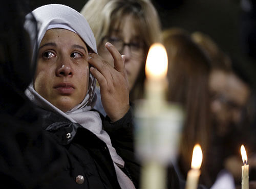 An attendee reflects on the tragedy of Wednesday's attack during a candlelight vigil in San Bernardino. Reuters photo