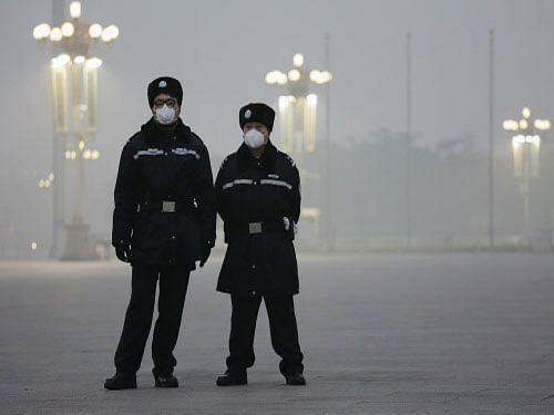 Policemen wear protective masks at Tiananmen Square on an extremely polluted day as hazardous, choking smog continues to blanket Beijing. Reuters photo