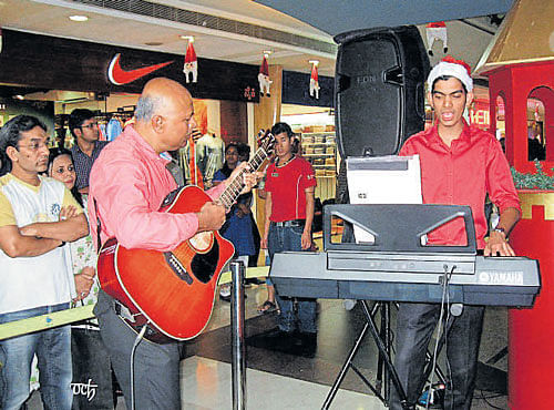 The author's father, Patrick A Kempu (on the guitar) and Lionell Dias (on the keyboard) perform at the The Forum Mall last Christmas.