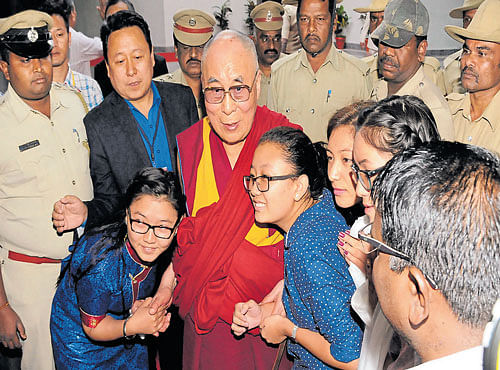Tibetan spiritual leader, the Dalai Lama, blesses people after unveiling the foundation plaque of the Integrated Centre for Yoga at the National Institute of Mental Health And Neuro Sciences (Nimhans) convention centre in Bengaluru on Monday. DH PHOTO