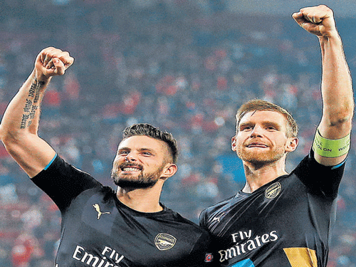 Arsenal's Olivier Giroud (left) with team-mate Per Mertesacker after their win over Olympiacos. Reuters