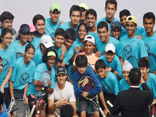 Spain's Rafael Nadal poses for a group photo with young fans at a promotional event in New Delhi on Thursday. PTI Photo