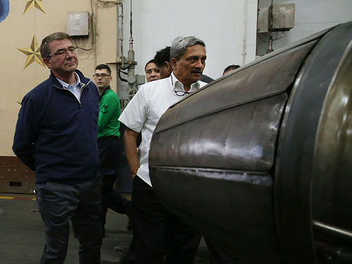U,.S. Defense Secretary Carter and India's Minister of Defense Parrikar inspect a jet engine in the hanger deck of the USS Eisenhower off the coast of Virginia. Reuters