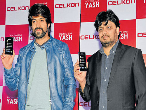 Kannada Film Actor and Celkon Mobiles brand ambassador Yash and Celkon Mobiles Executive Director Murali Retineni pose with Celkon models as part of announcing the former as the company's Karnataka brand ambassador, in Bengaluru on Friday. DH PHOTO BY S K DINESH