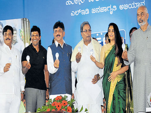 Chief Minister Siddaramaiah holds LED bulbs at the launch of the 'Hosa Belaku' scheme on Friday. Also seen are (fromleft) PublicWorks Minister H C Mahadevappa, actor Puneeth Rajkumar, Energy Minister D K Shivakumar, actress Ramya and Sericulture and Animal Husbandry Minister A Manju. DH PHOTO