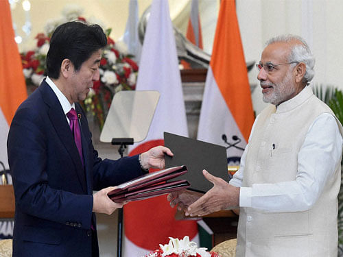 Prime Minister Narendra Modi and his Japanese counterpart Shinzo Abe exchange documents after signing an agreement at Hyderabad House in New Delhi on Saturday. PTI Photo
