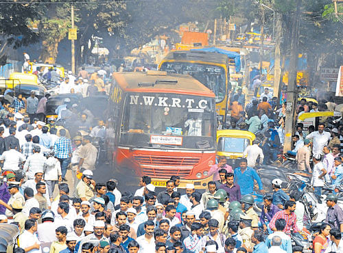 RIOTOUS: A mob set a bus on fire in Old Hubballi area onMonday. DH PHOTO