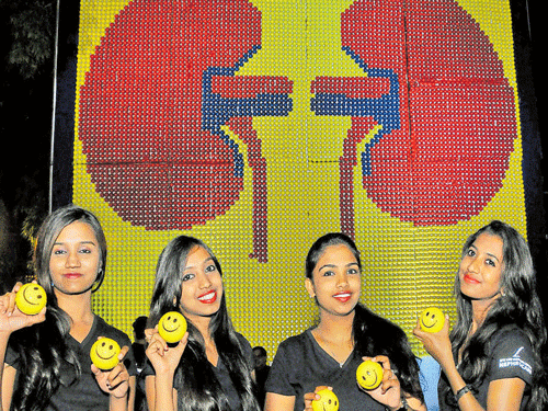 Girls pose in front of a display of the world's largest kidney model comprising 10,000 stress balls, exhibited by officials of RPG Life Sciences Limited during the ISNCON 2015 in Bengaluru on Thursday. DH PHOTO