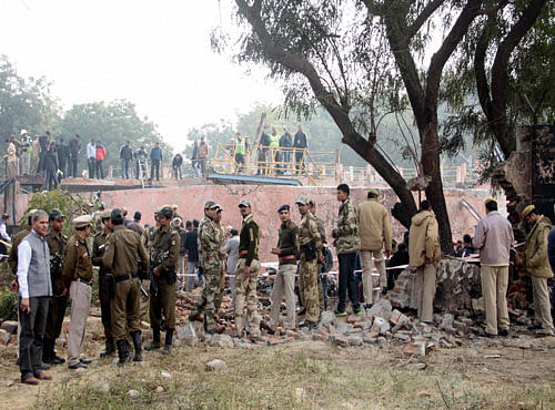 Security personnel near the wreckage of a Border Security Force (BSF) aircraft which crashed near Dwarka in Delhi on Tuesday. PTI Photo