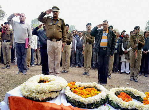 Police officers paying tribute to ASI Ravinder Pal Chauhan who died in BSF plane crash in Delhi, during his funeral at his native village Mawepur in Meerut district on Wednesday. PTI Photo