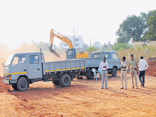 Ground-clearing work is under way to build an approach road to the railway underbridge at Adarsh Colony in Bidar on Thursday. (Below) Defence personnel gather at the spot. DH&#8200;PHOTOs