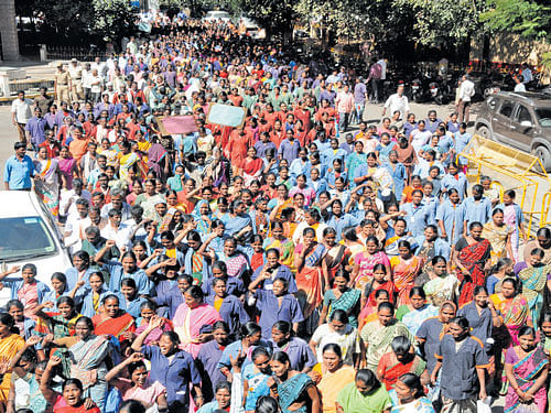 Municipalworkers stage a huge protest in front of the BBMP head office in the City on Tuesday. DH PHOTO