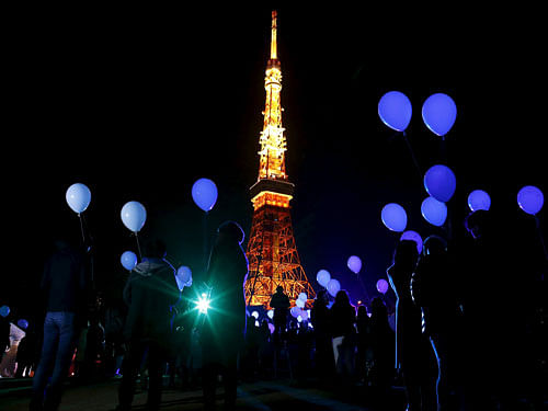 People hold balloons to release them at the turn of the New Year at a hotel in front of the landmark Tokyo Tower in Tokyo, Japan, December 31, 2015, REUTERS Photo