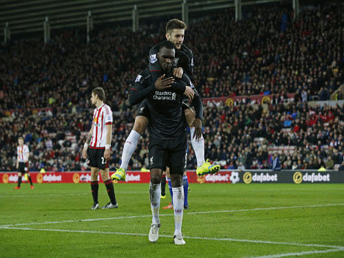 Christian Benteke celebrates scoring the first goal for Liverpool with Adam Lallana. Reuters