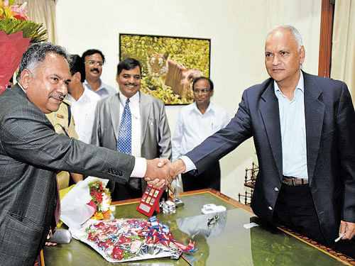 Retiring Chief Secretary Kaushik Mukherjee (left) greets  his successor Arvind Jadhav at the Vidhana Soudha in  Bengaluru on Thursday. DH photo