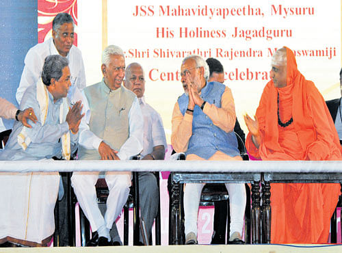 GREETINGS: Prime Minister Narendra Modi greets Chief Minister Siddaramaiah during the birth centenary celebrations of Shivaratri Rajendraswami in Mysuru on Saturday. Also seen are Governor Vajubhai Rudabhai Vala and Suttur seer Shivaratri Deshikendra Swami. DH PHOTO
