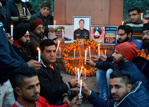 People and members of National Human Rights and Crime Control Organization light candles in front of portraits of Indian Security Personnel who lost their lives in the Pathankot militant attack at Air Force base, during a tribute paying ceremony in Amritsar, on Sunday. PTI Photo