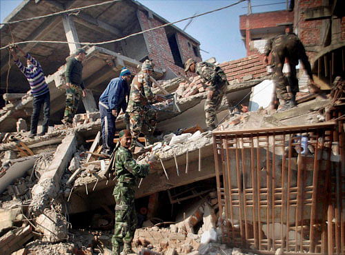 Soldiers and locals remove debris from a damaged building after an earthquake in Imphal, Manipur on Monday. A 6.7 magnitude earthquake hit the northeast region before dawn. PTI Photo