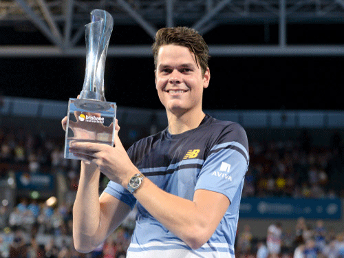 Milos Raonic of Canada holds the men's singles trophy after defeating Roger Federer of Switzerland at the Brisbane International Tennis Tournament in Brisbane, Australia. Reuters Photo.