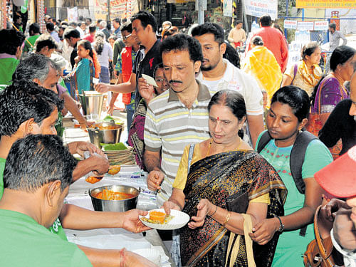 delicious Visitors enjoying the 'Avarekai Mela' and (right) 'kodubale'. Dh Photo by SK Dinesh