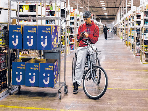 Like other Jet.com employees, Jesus Ruperto rides a cargo tricycle around the huge warehouse to save time while filling orders. The start-up's founder says the happiness of his employees will separate Jet.com from other failed ventures in the US market. NYT