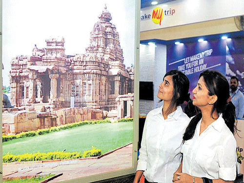 Enthralled visitors look at a poster on Chalukyan architecture at the Karnataka pavilion at TTF in Bengaluru on Friday. DH&#8200;Photo by Kishor Kumar Bolar