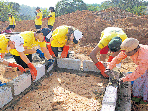A group of American students work with Indian rural women to build toilets at Sulagodu in Shivamogga district. dh photo