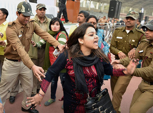 Policemen try to control a member of Aam Aadmi Sena after she splattered Delhi CM Arvind Kejriwal with ink while protesting against the CNG scam, at a 'thanksgiving rally following the "success" of his government's odd-even scheme at Chhatrasal Stadium, in New Delhi on Sunday. PTI Photo