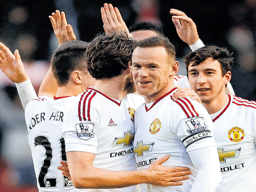 VITAL STRIKE Wayne Rooney (second from right) celebrates with team-mates after scoring against Liverpool. REUTERS