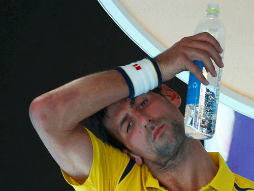 Serbia's Novak Djokovic wipes his forehead as he drinks water during his first round match against South Korea's Hyeon Chung at the Australian Open tennis tournament at Melbourne Park, Australia, January 18, 2016. REUTERS