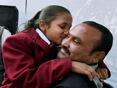Eight-year old Shivampet Ruchitha of Telangana who will be honoured with National Bravery Award 2015 shares a light moment with her father during a press conference in New Delhi. PTI photo